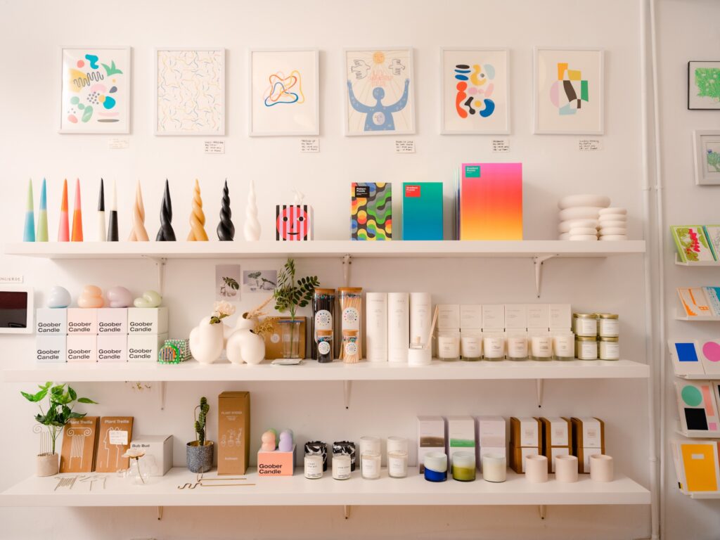 Colorful and bright gift shop display of candles, prints, and plant holders.