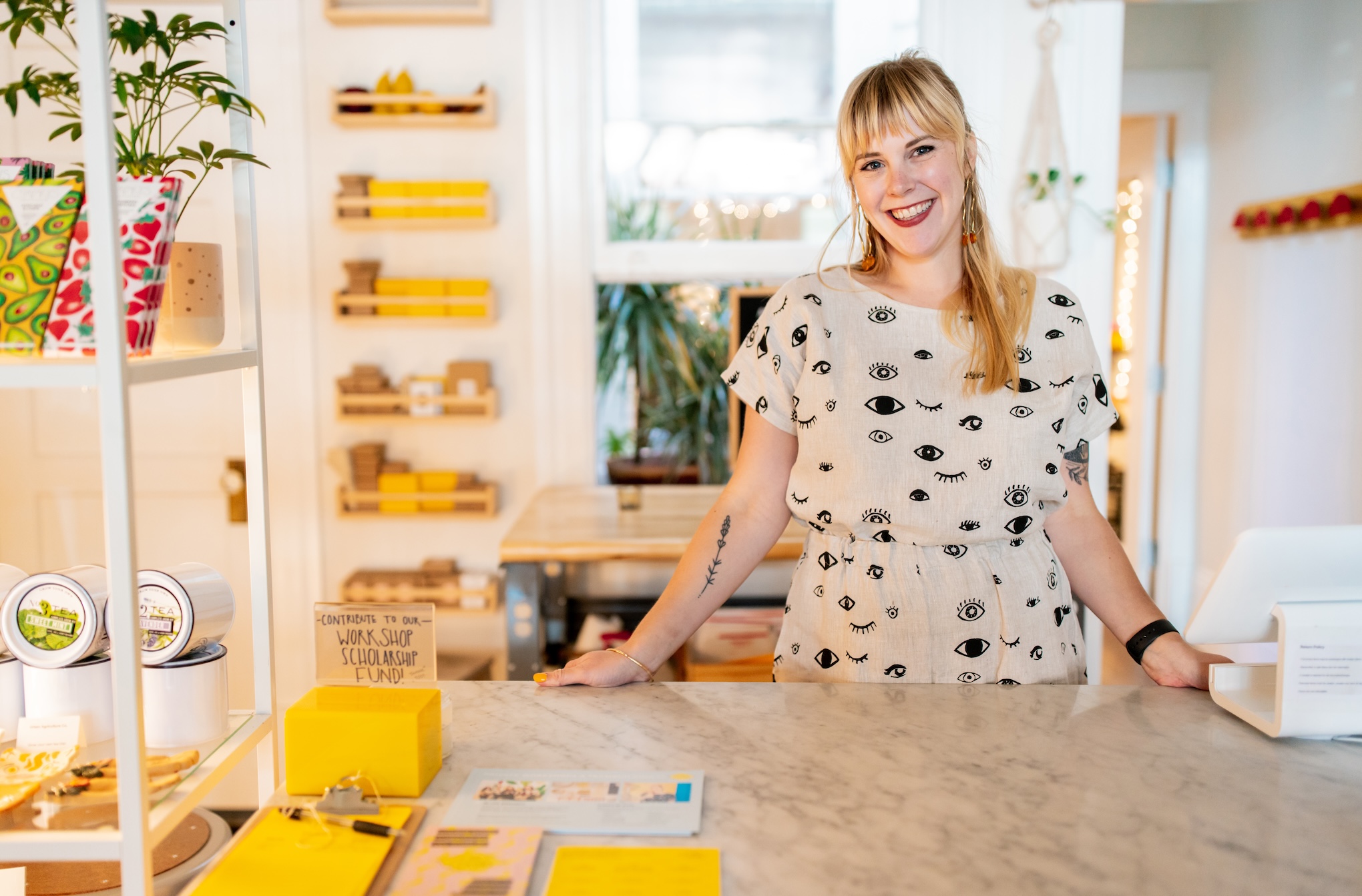 a smiling shopkeeper stands at a counter