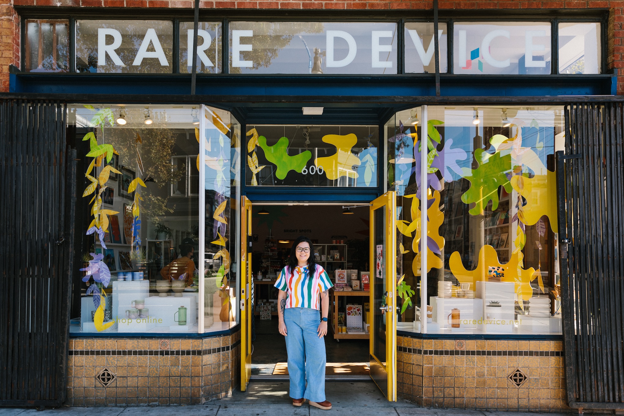 female shopkeeper stands in front of her store