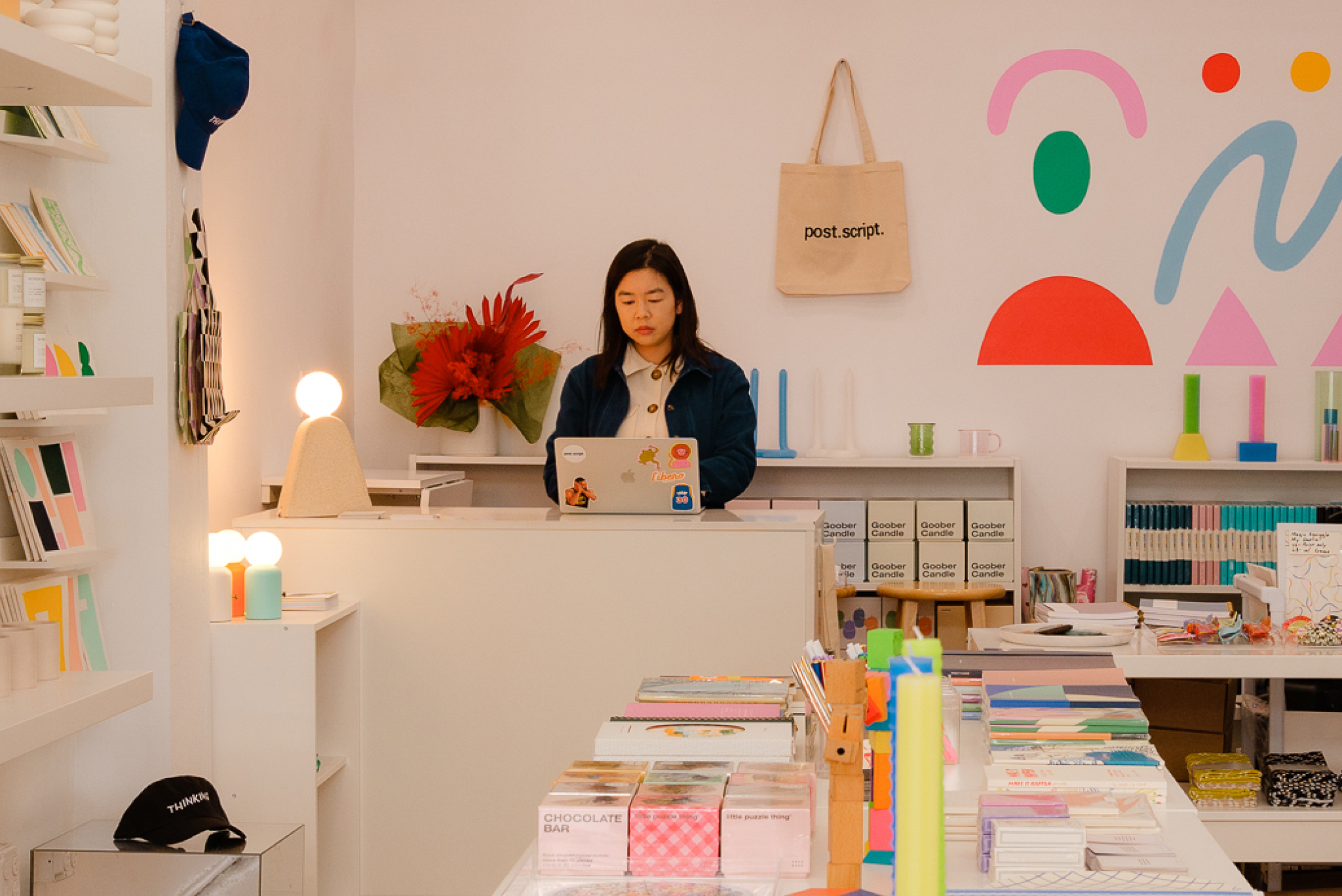 a shopkeeper stands behind the cash register