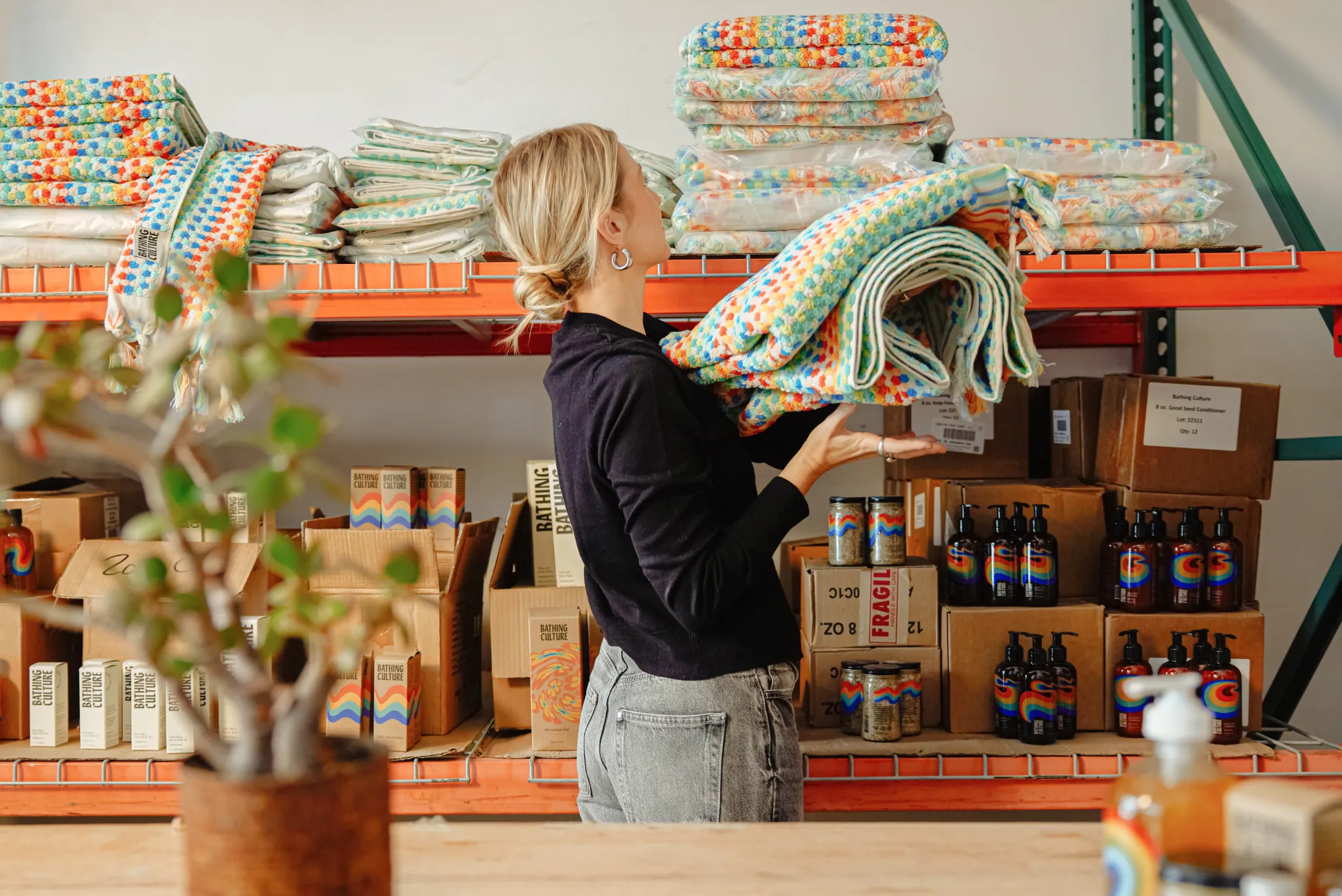 a blonde person stocks blankets on shelves