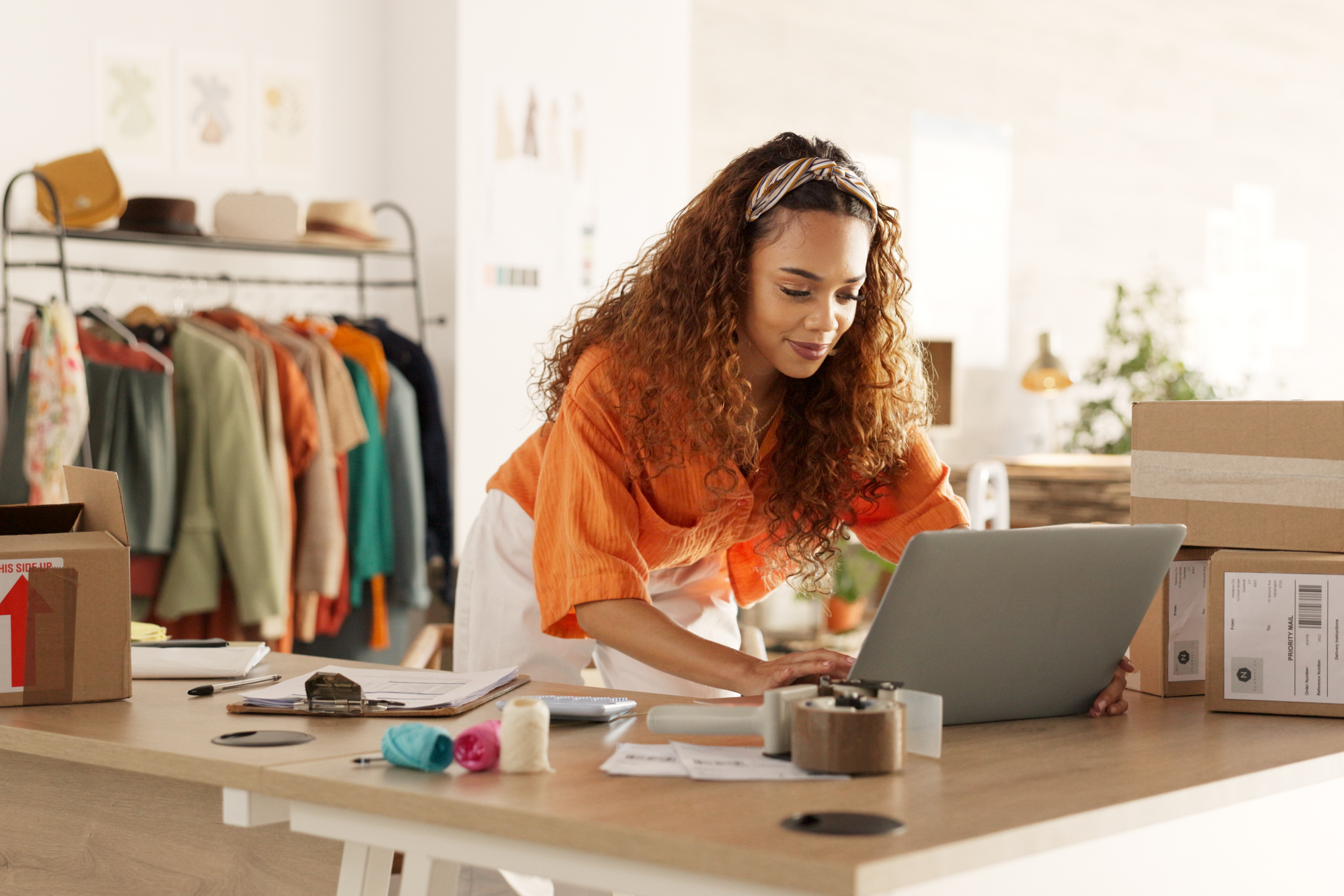 Eine Ladeninhaberin aktualisiert ihre Online-Marketing-Präsenz über ihren Laptop