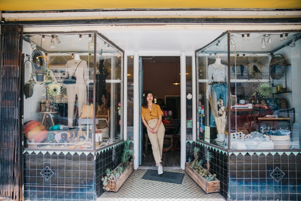 Commerçante devant la vitrine de sa boutique, en attente du début des soldes