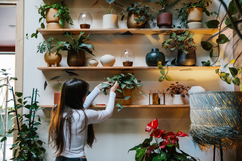 Vendeuse en train d'entretenir les plantes de sa boutique de produits éco-responsables