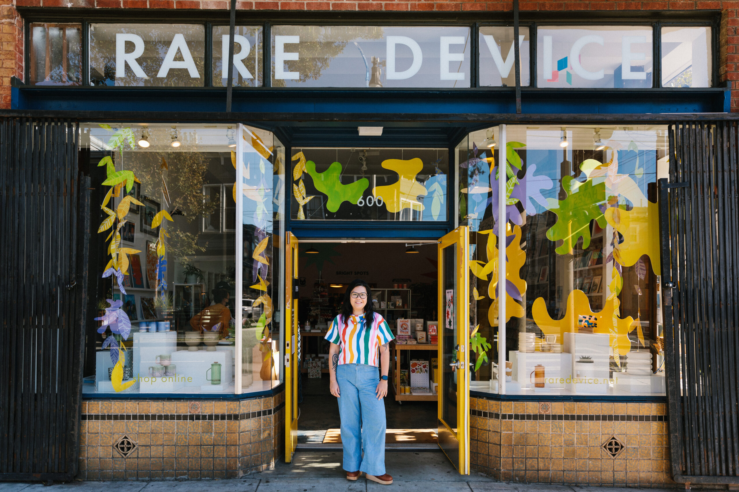 Une petite entrepreneure se tient à l'entrée de son magasin physique